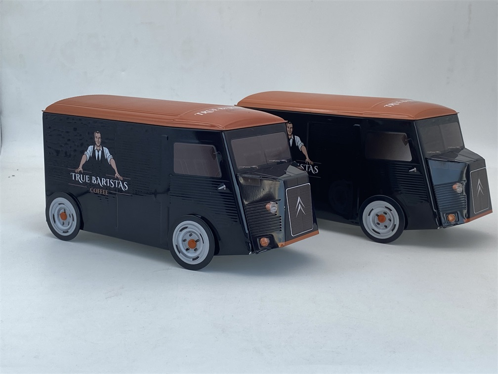 Physical production samples of custom truck-shaped coffee tins, demonstrating high-quality metal printing and embossing details.