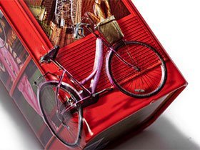 Red metal container with detailed 3D bicycle embossing by a professional tin box manufacturer.
