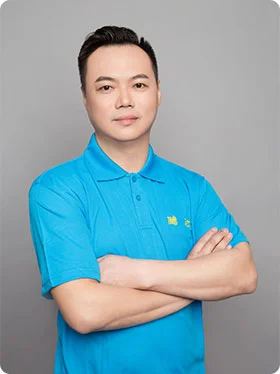 Portrait of Sam, the Plant Manager, wearing a bright blue polo shirt and standing with arms crossed.