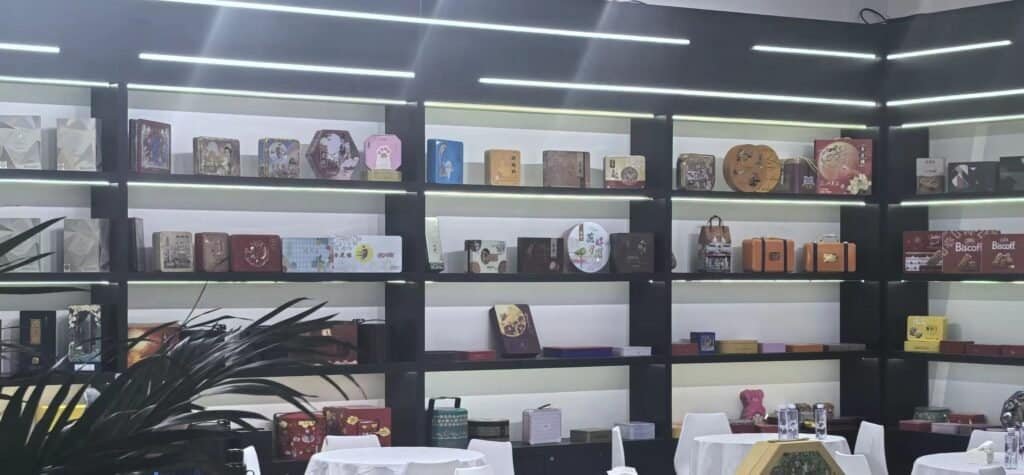 Custom tin box samples displayed on exhibition table including round, square and gift tins