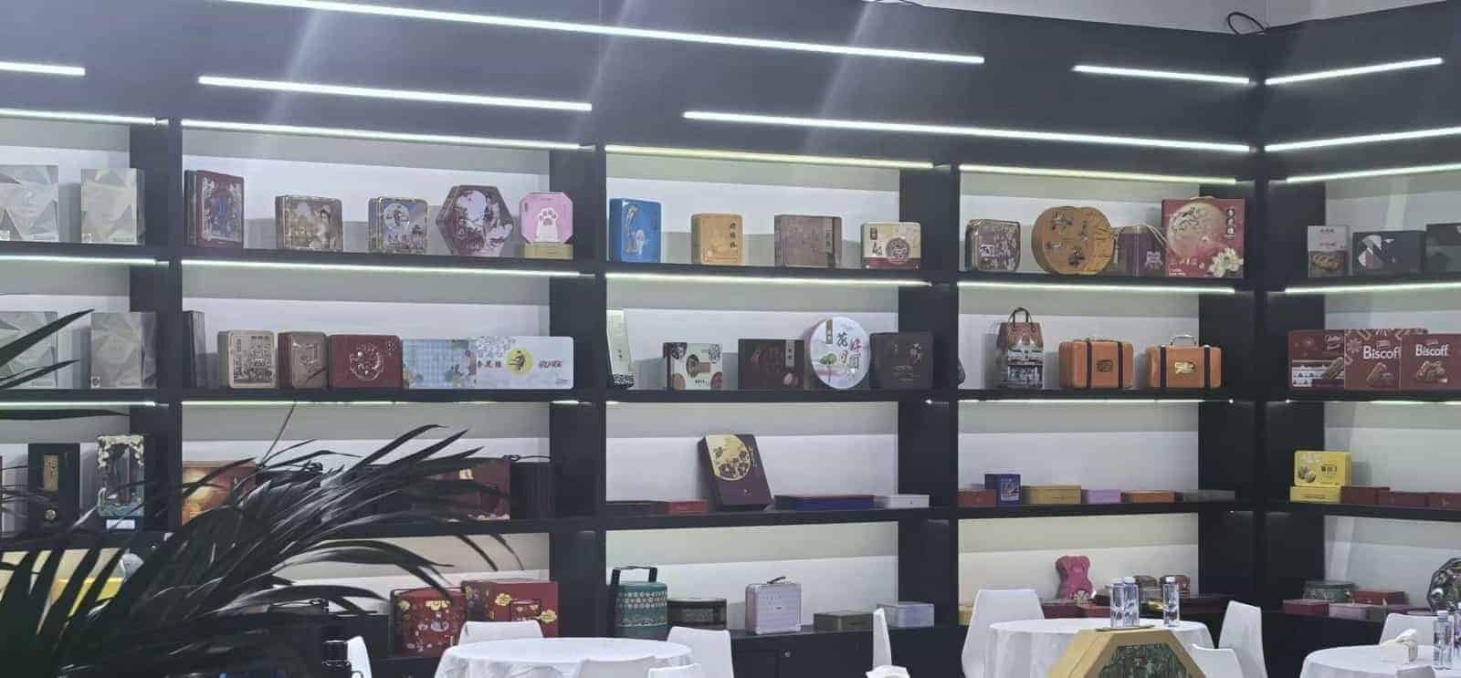 Shelves displaying tin packaging samples in different shapes, sizes and printed designs
