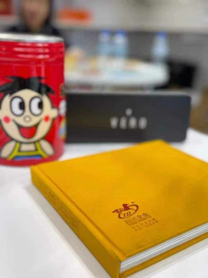 Tin packaging display featuring a red character tin, a dark rectangular tin and a yellow rectangular tin