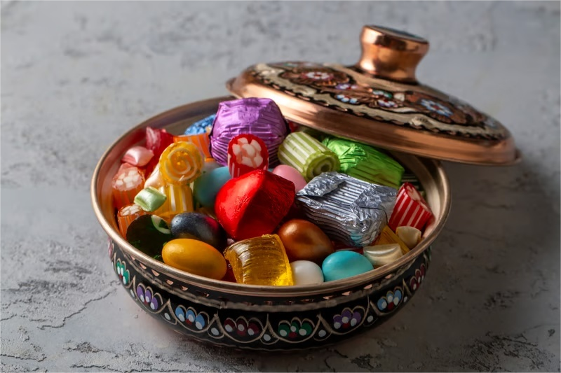 Decorative candy tin filled with assorted wrapped sweets