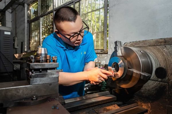 Expert mold engineer debugging a precision mold for custom tin box production to ensure perfect fit and quality.